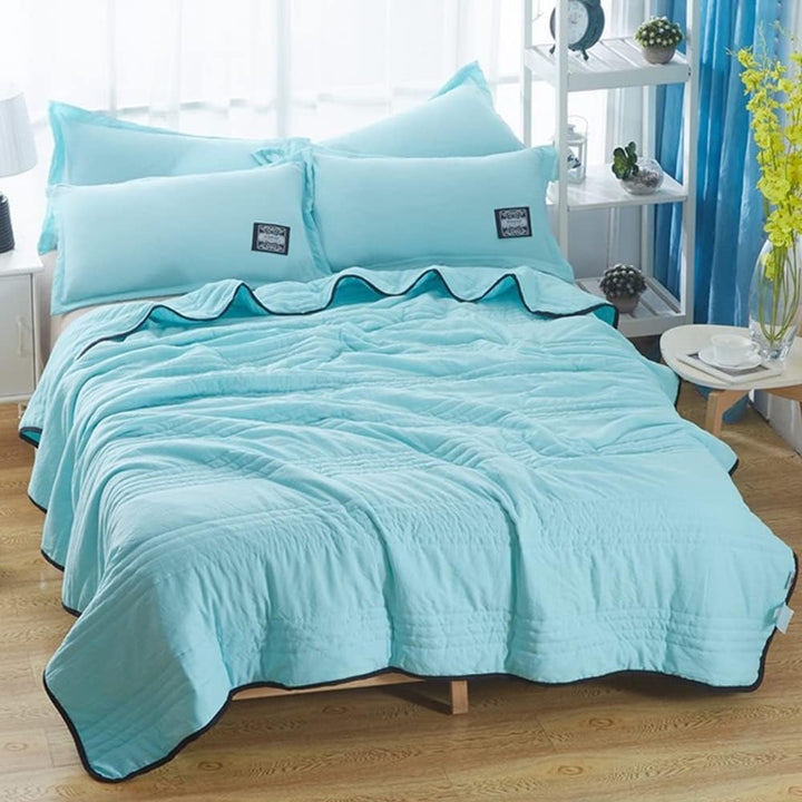 Slaapkamer met een opgemaakt bed en het verkoelend zomerdeken, uitnodigend voor een frisse slaapervaring.