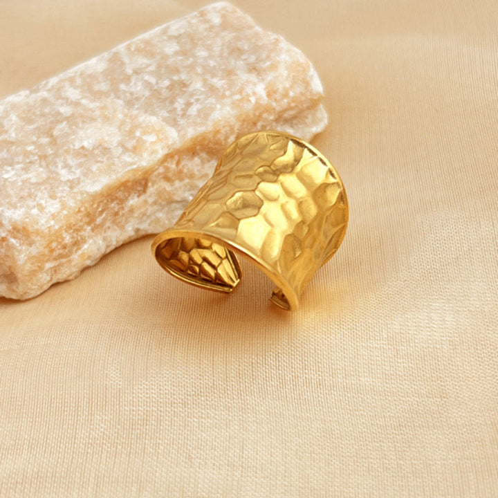 Brede gouden open ring unisex, edelstaal. Gehamerd watergolfpatroon voor een modieus statement sieraad.
