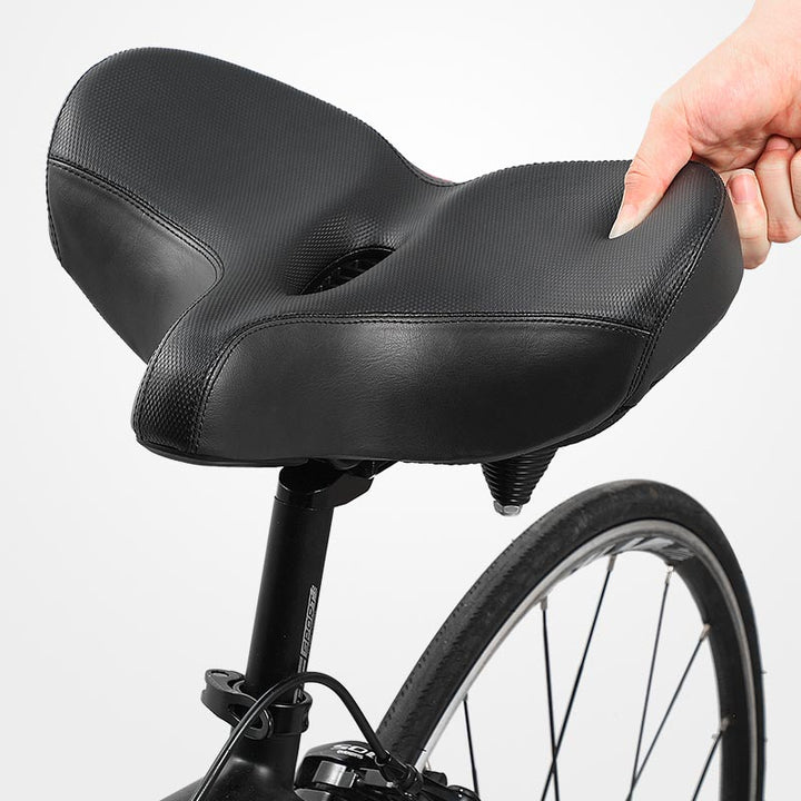 Zijaanzicht van het comfortabele fietszadel, benadrukt de ergonomische vorm en brede constructie.