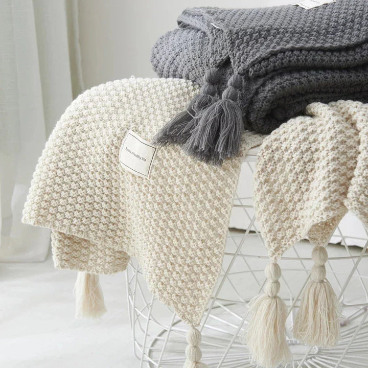 Creëer een huiselijk gevoel met deze gebreide wollen deken met kwastjes; comfort en stijl van NordicCozy.