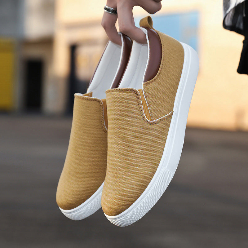 Zijkant van een grijze canvas heren slip-on schoen, met comfortabele zool en elastische instap.