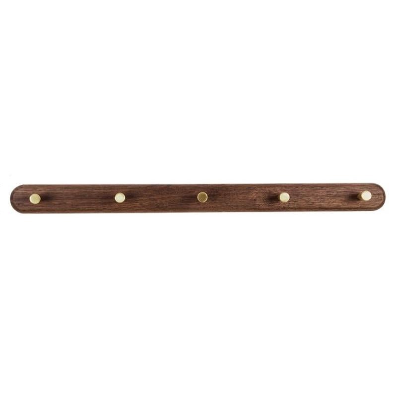 Houten muurkapstok met messing haken voor het geordend opbergen van kleding in een moderne hal.