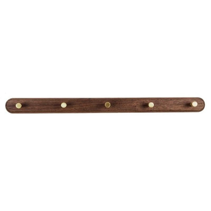 Houten muurkapstok met messing haken voor het geordend opbergen van kleding in een moderne hal.