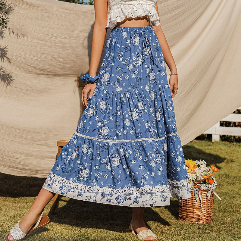 Vloeiende damesrok met blauwe bloemenprint en hoge taille, perfect voor lente en zomer.