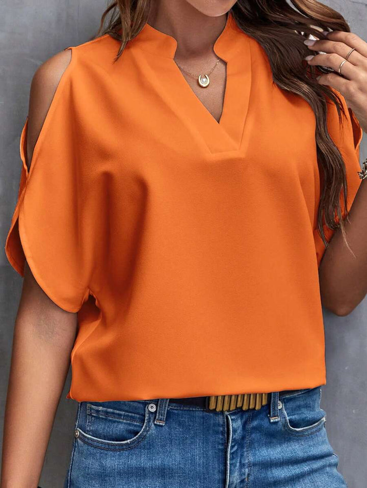 Trendy oranje dames blouse met cut-out schouders en V-hals, een must-have voor lente en zomer fashion.