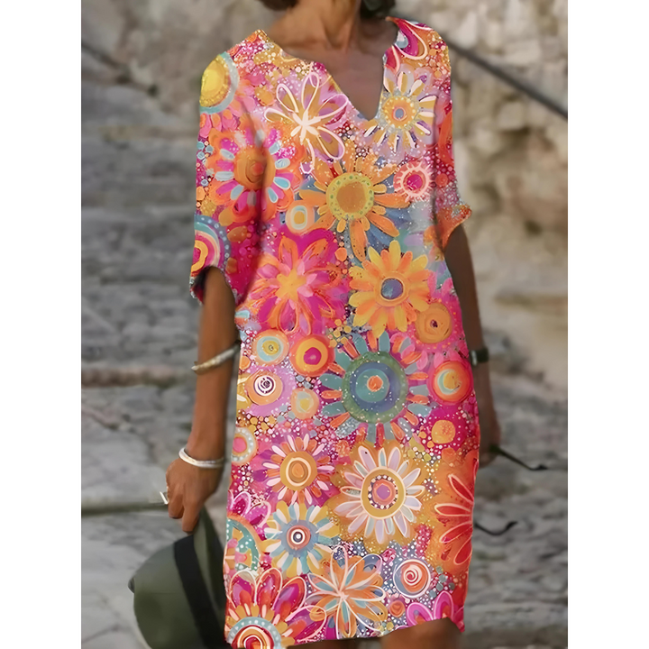 Flatterende casual damesjurk met V-hals, korte mouwen en bloemenprint in geel, groen en roze.