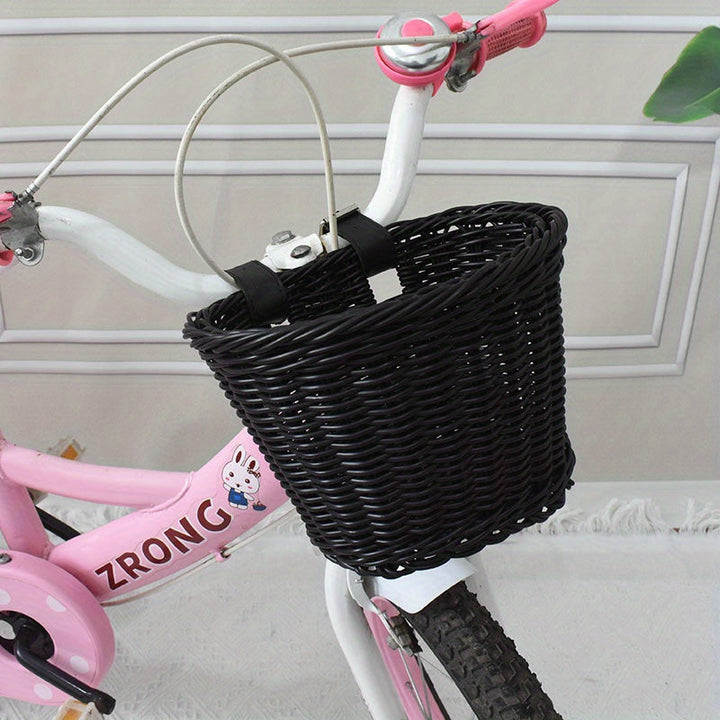 Roosrode handgeweven fietsmand van duurzaam plastic riet voor een vrolijke kinderfiets.