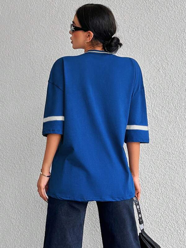 Trendy zwart oversized dames shirt in baseball stijl, perfect voor een casual en sportieve streetwear outfit.