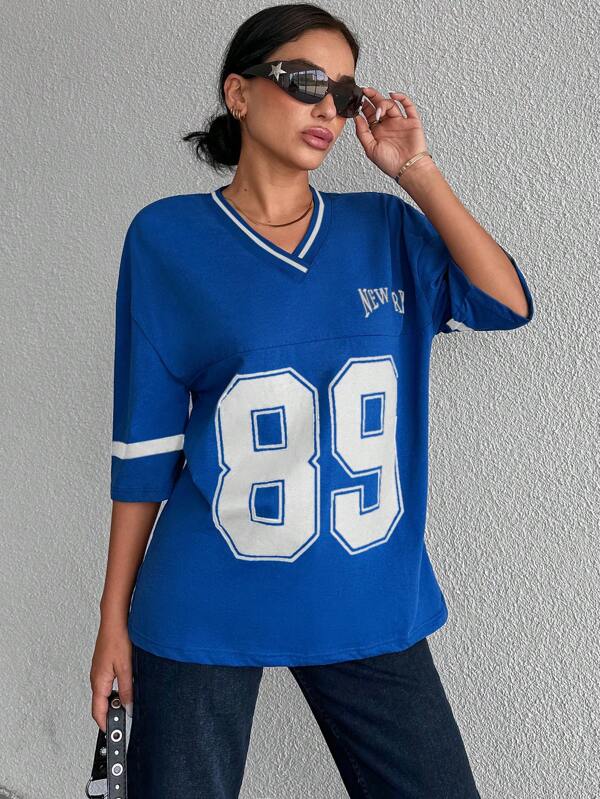 Relaxed zwart dames shirt in baseball/voetbal stijl, oversized en trendy voor een coole casual outfit.
