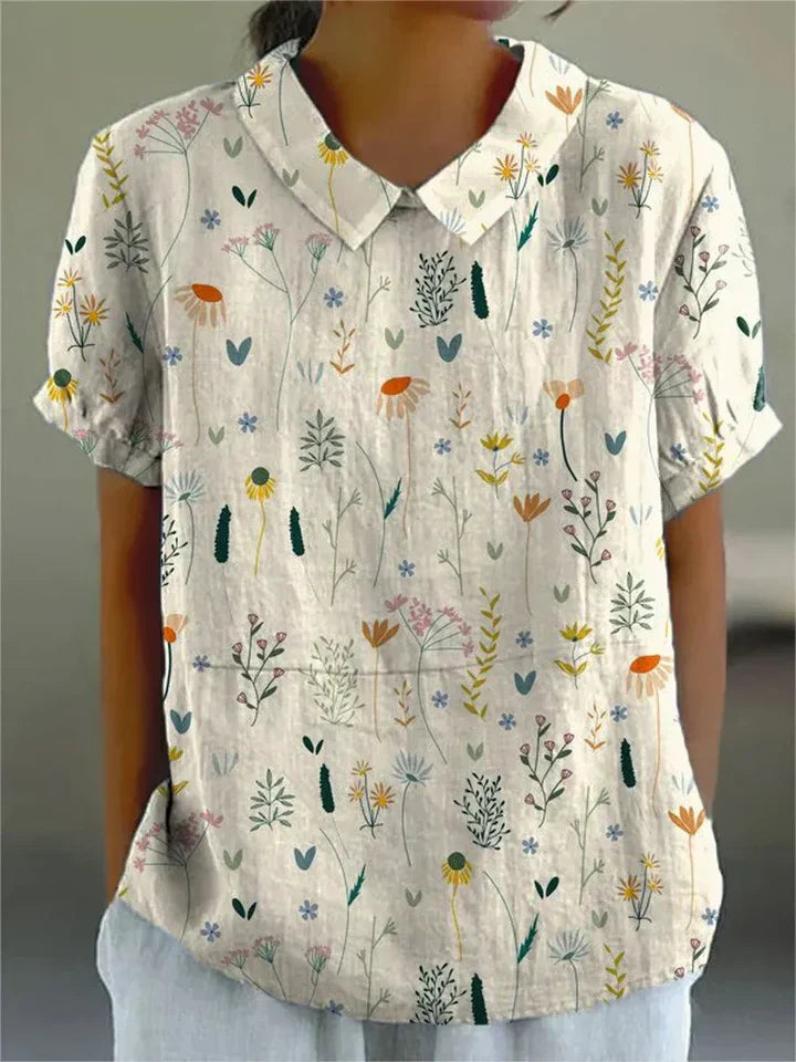 Witte dames wildflower blouse met romantische bloemenprint, V-hals en lange mouwen. Ideaal voor lentemode.