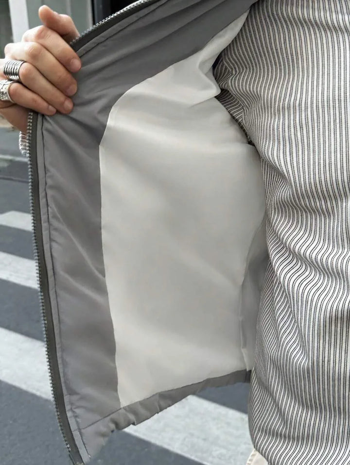 Veelzijdig grijs heren pufferjack met capuchon; essentieel voor winterse kou. Comfortabel, warm en modern.