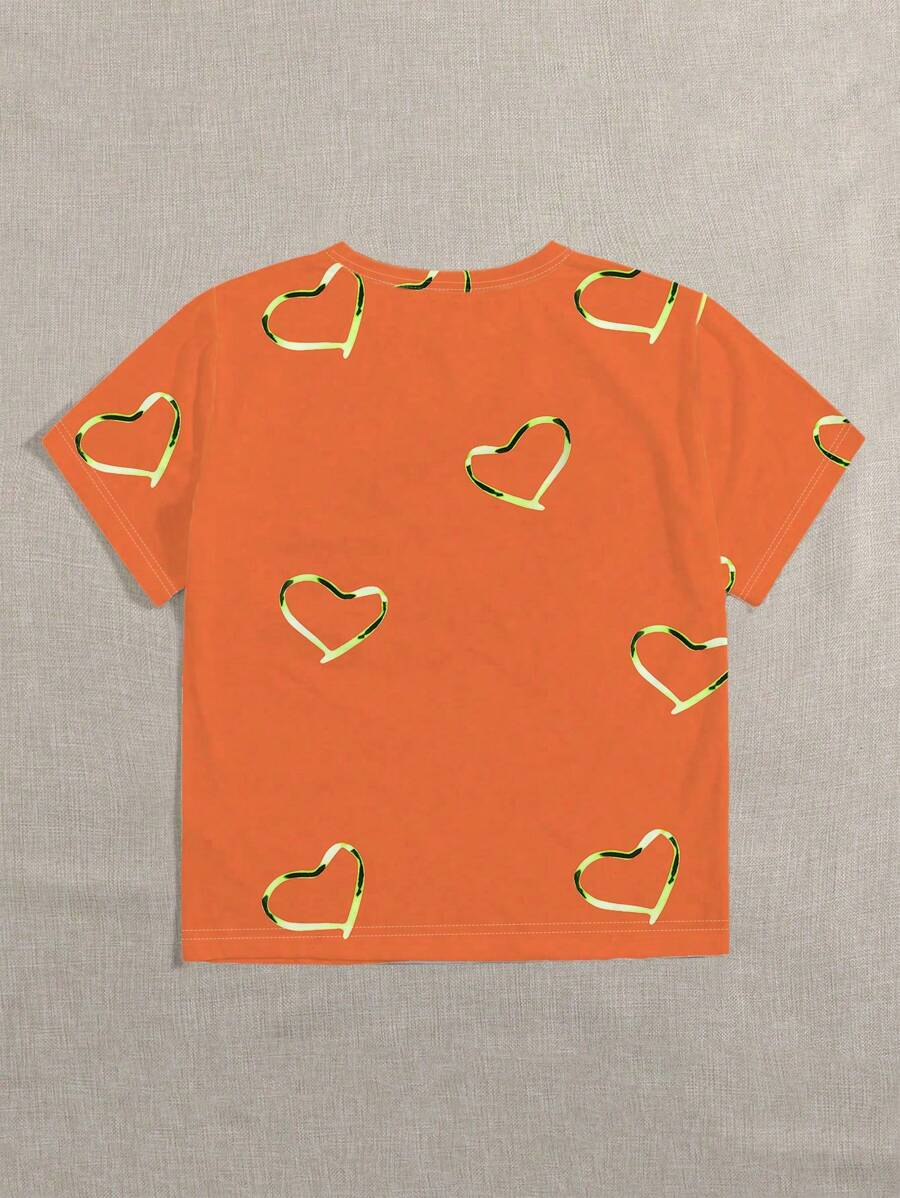 Dames shirt oranje met speelse hartjesprint. Ideaal voor Koningsdag, festivals of vrolijke lente/zomer outfits.