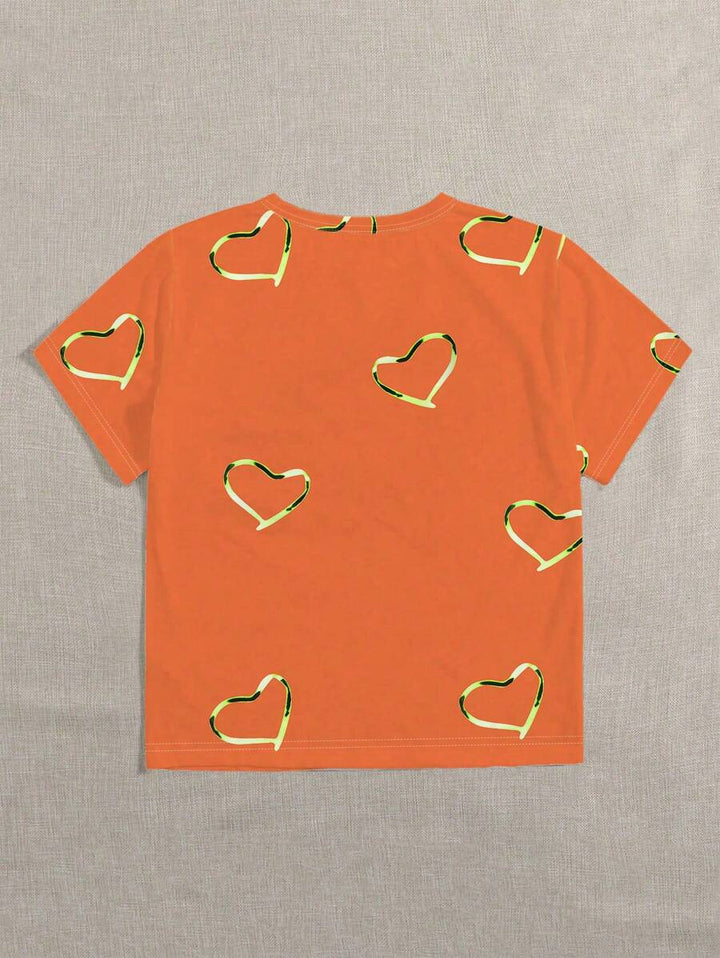 Dames shirt oranje met speelse hartjesprint. Ideaal voor Koningsdag, festivals of vrolijke lente/zomer outfits.