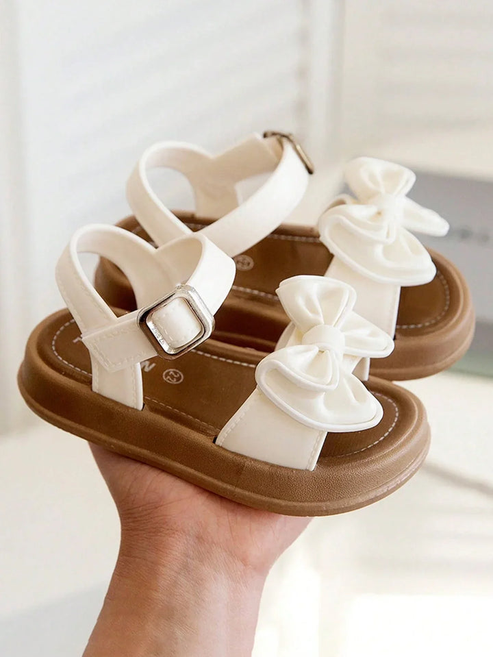 Elegante meisjes prinsessensandalen met strikje in roze. Stijlvolle zomerschoenen voor elke kleine prinses.