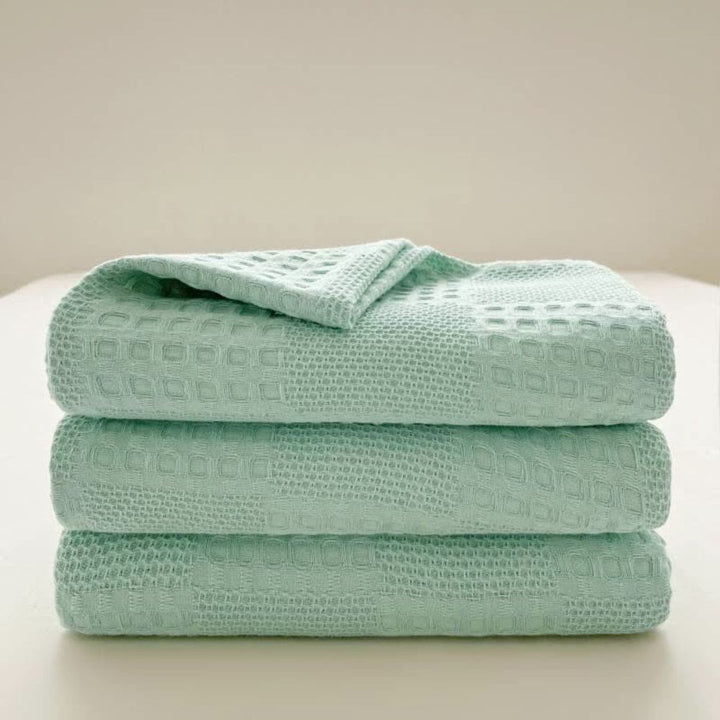Stijlvolle biologisch katoenen wafeldeken als decoratieve plaid over een fauteuil, een comfortabel huistextiel.