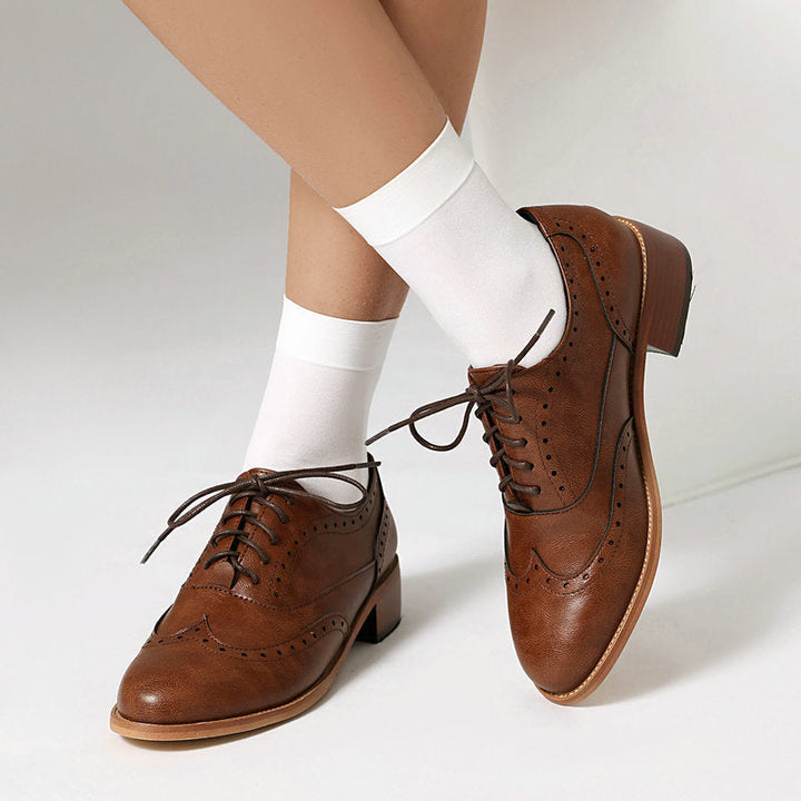 Elegante dames veterschoenen met stijlvolle perforaties, perfect voor kantoorlooks en formele gelegenheden.