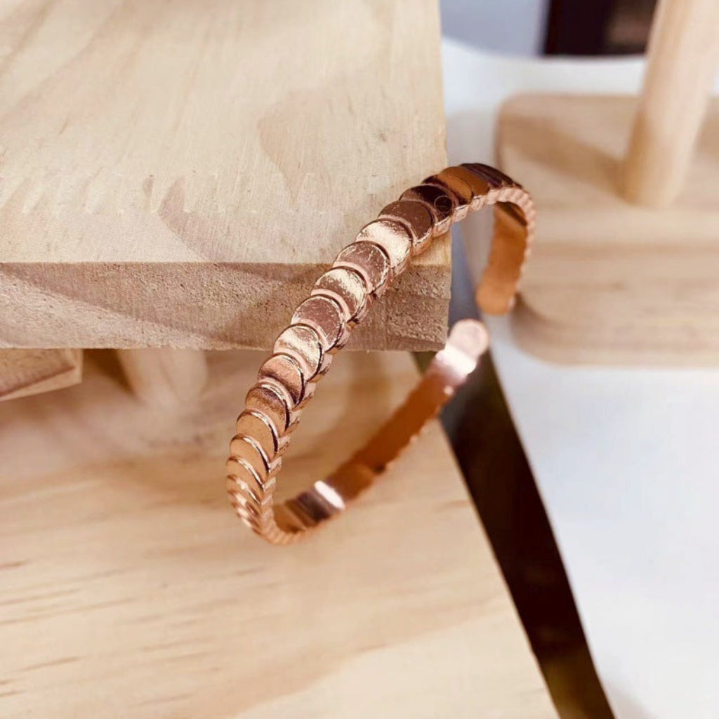 Elegante glanzende roodkoperen dames armband, trapvormige bangle. Luxe gelaagd sieraad voor moderne vrouwen.