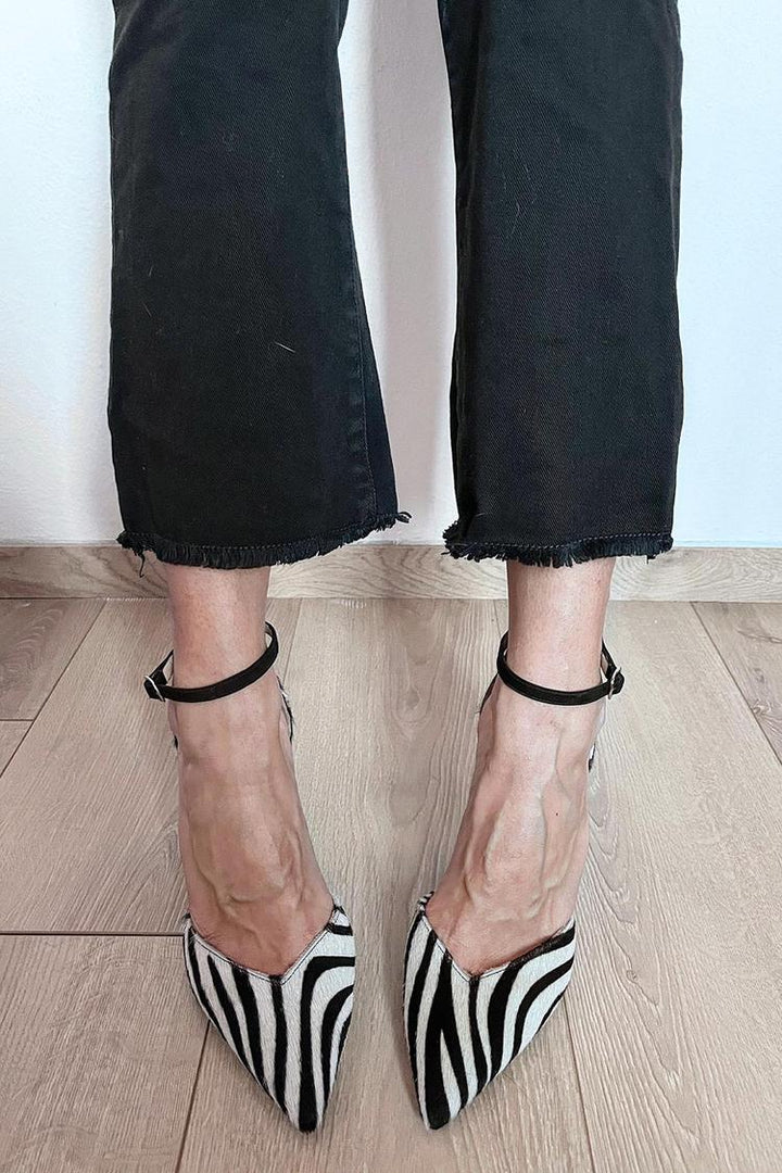 Stijlvolle damesschoenen met opvallende zebraprint, smal enkelbandje en elegante hak. Trendy en chique.