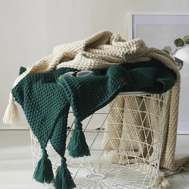 Gebreide wollen deken met kwastjes, ideaal voor comfort en warmte in de woonkamer.