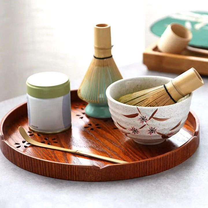 Diverse theebenodigdheden: bamboe klopper, lepel en theekom voor een complete Japanse matcha set.