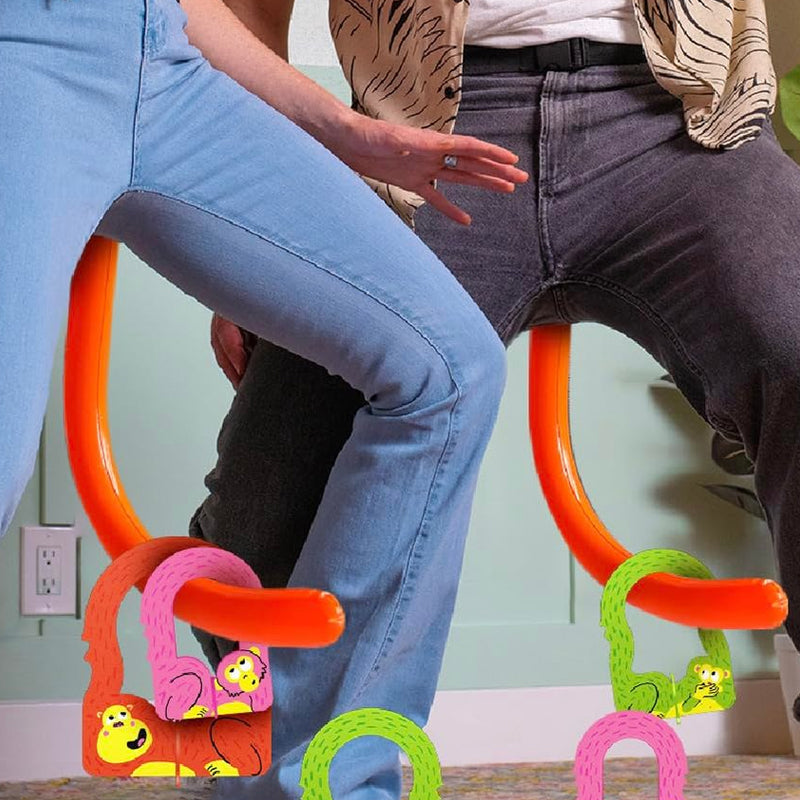 Een familie speelt enthousiast het Swingo staartspel binnen, lachend en actief bezig. Groot groepsspel entertainment.