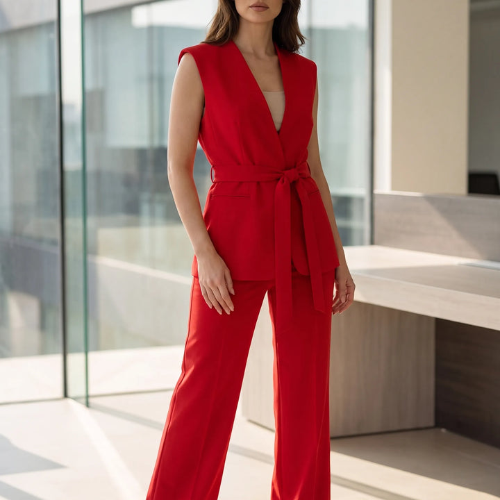 Elegant rood dames broekpak met overslagtop en rechte pijpen, ideaal voor chique of zakelijke gelegenheden.