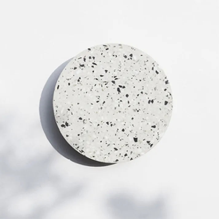 Dichtbij van de Scandinavische wandlamp, toont uniek terrazzo patroon en warm LED licht.
