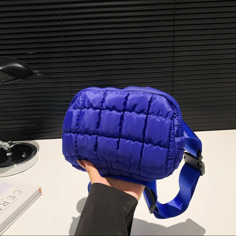 Vrouw draagt de trendy puffer crossbody tas, comfortabel en modieus als schoudertas.