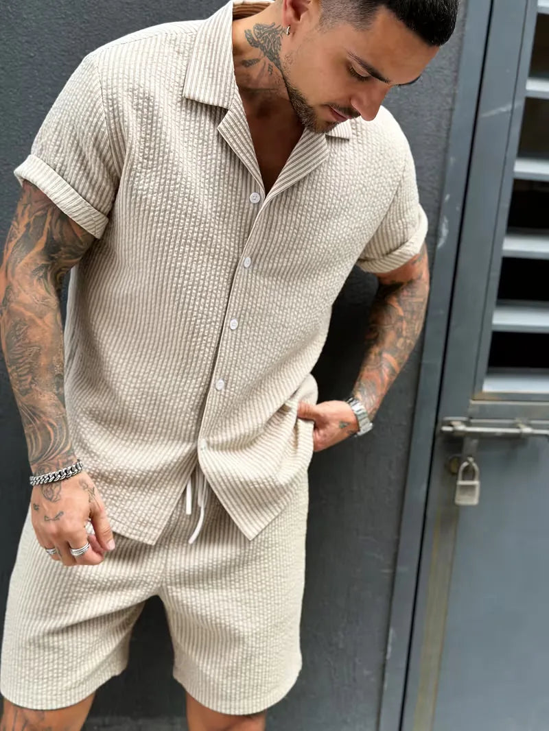 Heren korte mouwen set: lichtblauw gestreept V-hals shirt en effen beige shorts.