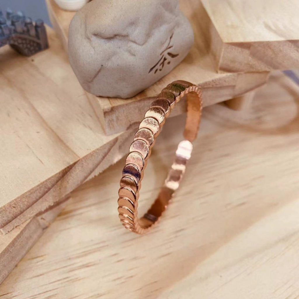 Stijlvolle trapvormige dames bangle, glanzend roodkoperen. Perfect elegant sieraad voor feestelijke gelegenheden.