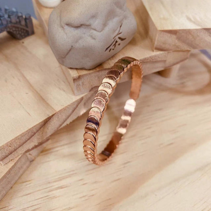 Stijlvolle trapvormige dames bangle, glanzend roodkoperen. Perfect elegant sieraad voor feestelijke gelegenheden.