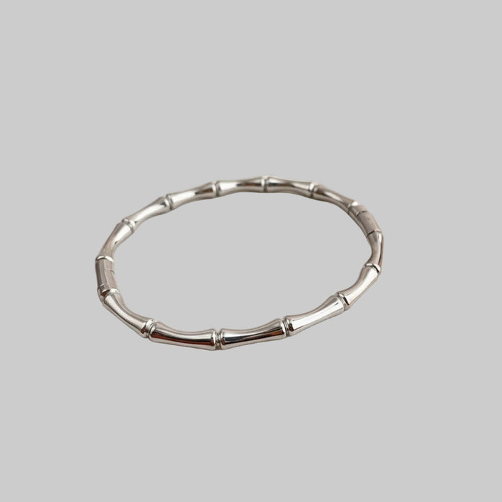 Elegante roségouden dames bamboeschakel armband. Minimalistisch ontwerp van titanium staal. Perfect accessoire.