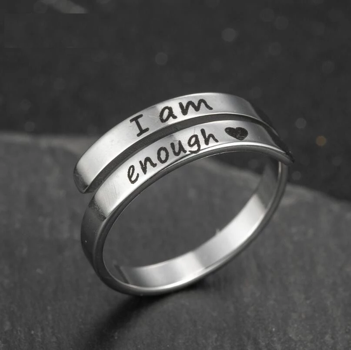 Detailopname van verzilverde damesring met duidelijke 'I Am Enough' inscriptie, stralend en inspirerend.