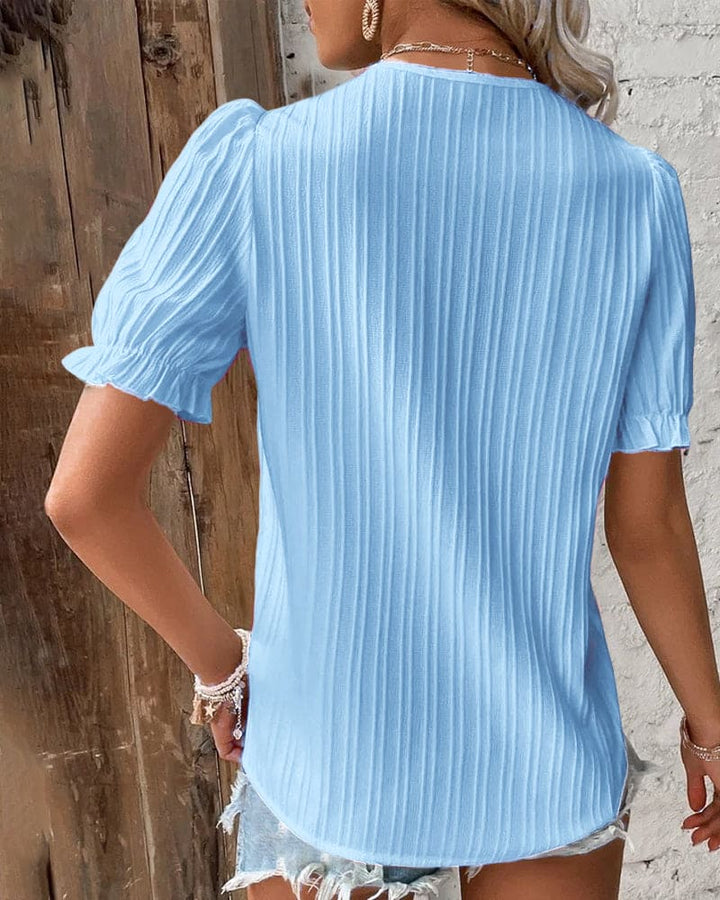 Verfijnde witte kanten blouse met V-hals, perfect voor een elegante dames outfit.