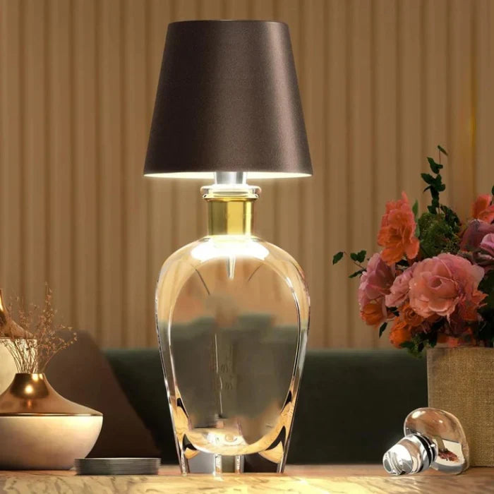 Draagbare LED fleslamp, oplaadbaar, staand op een houten tafel.