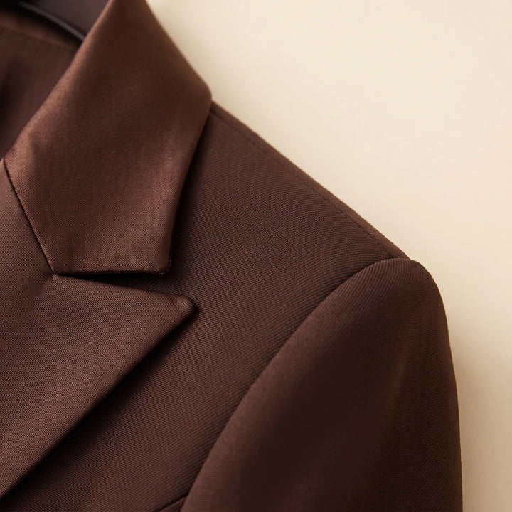 Bruin tweedelig damespak met elegante blazer en broek, perfect als comfortabele zakelijke outfit.