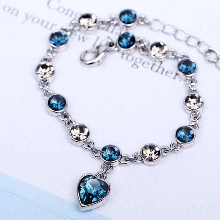 Close-up dames kristalarmband met blauwe hartbedel en zirkonia. Elegant verstelbaar sieraad voor vrouw.