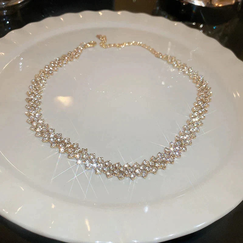 Chique gouden dames choker ketting met geometrisch geplaatste sprankelende kristallen steentjes, ideaal voor gala.