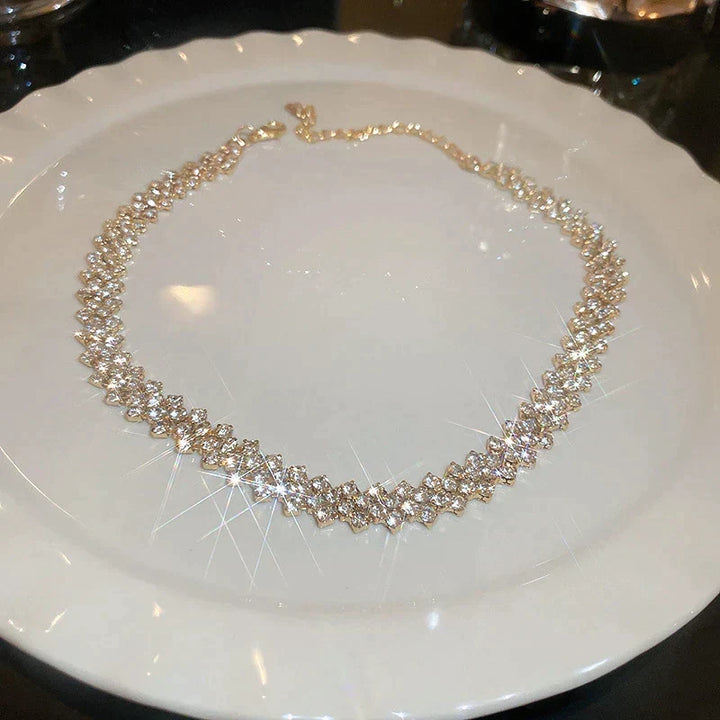 Chique gouden dames choker ketting met geometrisch geplaatste sprankelende kristallen steentjes, ideaal voor gala.