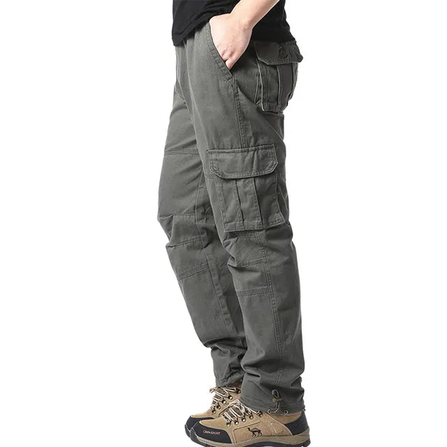 Model draagt casual heren cargobroek met grote zakken, ideaal voor een actieve levensstijl.