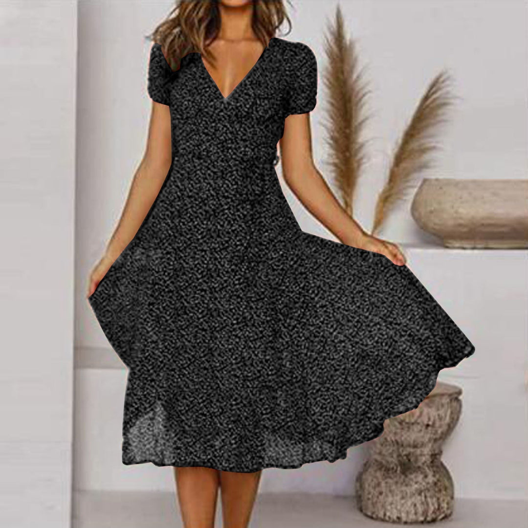Stijlvolle groene dames jurk met V-hals en kleurrijke bloemenprint. Elegante midi jurk, ideaal voor zomerfeesten.