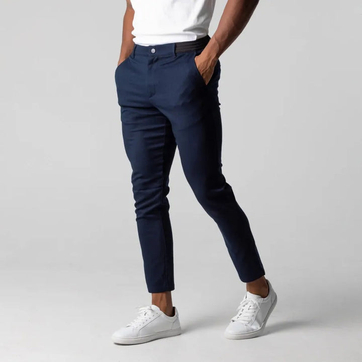 Man loopt in comfortabele grijze heren chino, benadrukt bewegingsvrijheid voor elke dag. Casual en stijlvol.