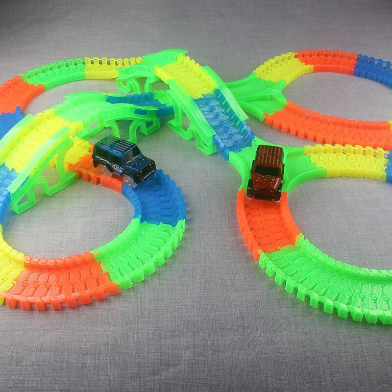 Kinderen spelen met modulaire glow in the dark racebaan en snelle LED speelgoedauto's.