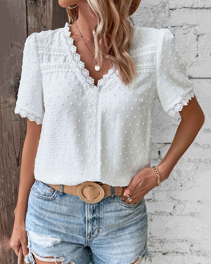 Witte damesblouse met kanten patroon, korte mouwen en V-hals, ideaal voor feestelijke gelegenheden.
