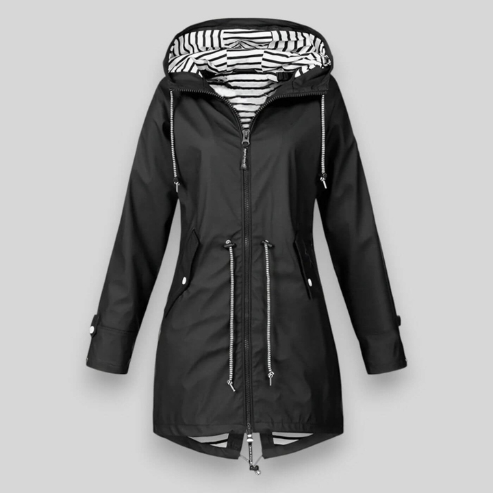 Vrouw draagt een modieuze waterdichte damesjas in een casual outdoor setting, met praktische capuchon.
