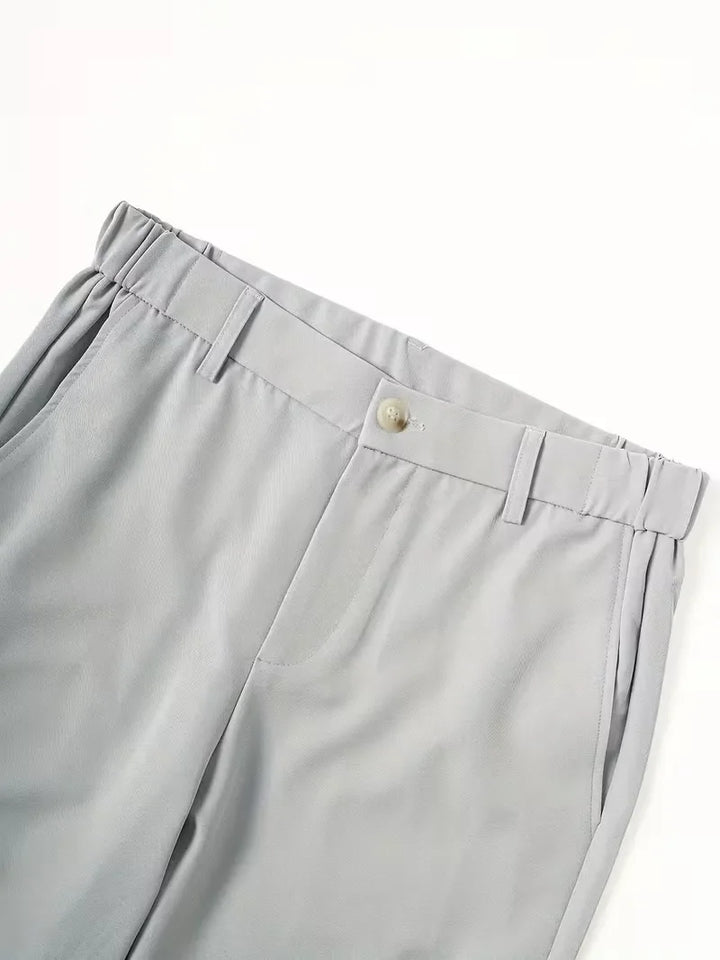 Achteraanzicht van heren chino shorts met paspelzakken en zijzakken, in een frisse zomerkleur.