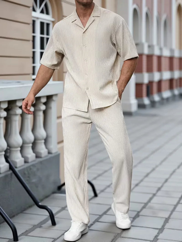 Stijlvolle heren zomeroutfit: beige V-hals shirt met korte mouwen en bijpassende lange broek, comfortabel casual.
