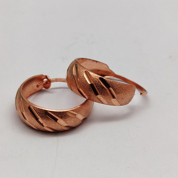 Prachtige roségouden dames sieraden oorbellen met subtiele koperen details en getextureerd design.