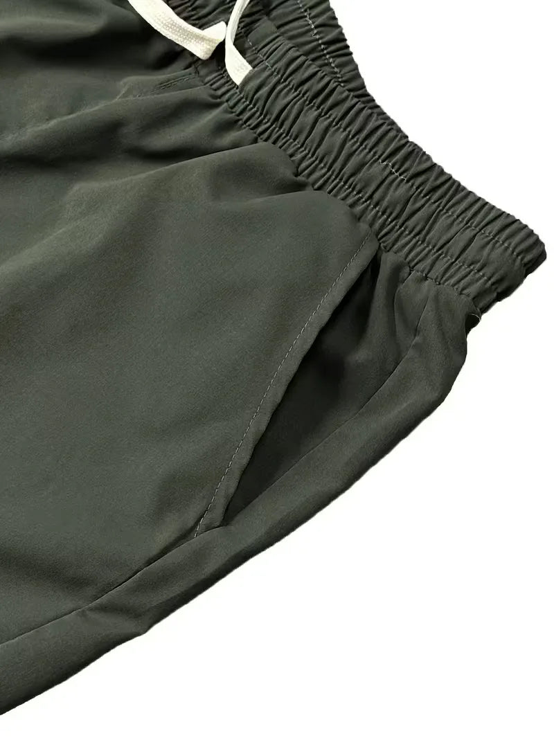 Detailopname van de ruime zijzakken op een heren taps toelopende cargo broek met elastische boorden.