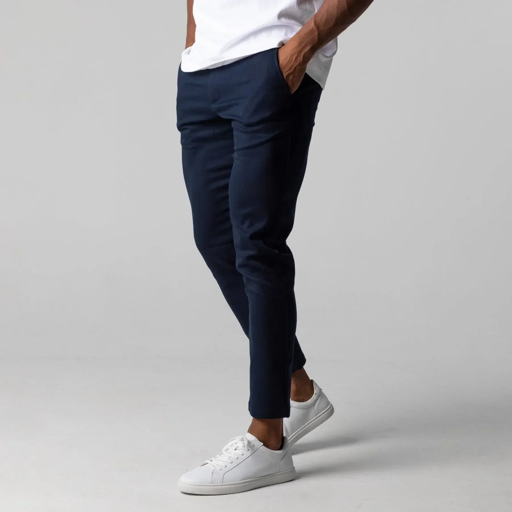 Man draagt een perfect passende marineblauwe heren chino, toont de moderne en elegante snit. Stijlvolle look.